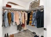 Thumbnail 17 of 27 - a closet with a rack of clothes and shoes