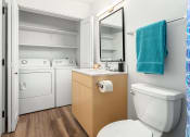 Thumbnail 25 of 27 - a bathroom with a toilet and a sink and a washing machine