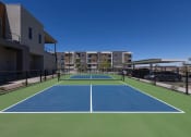 Thumbnail 50 of 59 - a blue and green tennis court with apartments in the background at Element 12 Apartments, Henderson NV