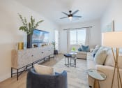 Thumbnail 16 of 59 - a living room with white furniture and a ceiling fan at Element 12 Apartments, Henderson NV