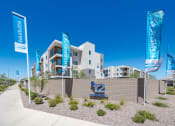 Thumbnail 51 of 59 - a building with flags and a sidewalk in front of it at Element 12 Apartments, Henderson NV