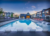 Thumbnail 26 of 42 - a swimming pool with chairs around it at dusk
