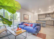 Thumbnail 2 of 42 - a living room with a blue couch and a coffee table