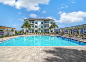 Thumbnail 1 of 30 - Resort-style swimming pool and apartment building at The Charles in Destin, Florida