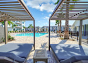 Thumbnail 4 of 30 - Covered outdoor lounge area overlooking the swimming pool at The Charles in Destin