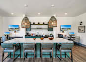 Thumbnail 16 of 30 - A modern resident kitchen with a large island and bar stools.
