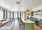 Thumbnail 17 of 30 - A modern resident kitchen and living room with a long island in the middle.