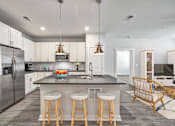 Thumbnail 24 of 30 - Modern apartment kitchen with island seating and stainless steel appliances