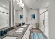 Thumbnail 30 of 30 - Modern apartment bathroom with vanity, mirror and glass-enclosed shower