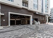 Thumbnail 29 of 34 - A building with a garage door open in front of it.