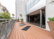 Thumbnail 26 of 34 - A wooden deck with yoga mats and a palm tree.