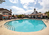 Thumbnail 5 of 63 - A large swimming pool in a resort with a building in the background.