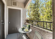 Thumbnail 19 of 63 - A balcony with a table and chairs and a bottle of wine.