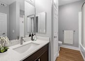 Thumbnail 25 of 63 - A bathroom with a sink, mirror, and toilet.