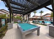 Thumbnail 49 of 63 - A pool table under a roof in a backyard.