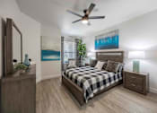 Thumbnail 11 of 63 - A bedroom with a bed, nightstand, and a mirror.