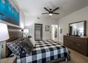 Thumbnail 12 of 63 - A bedroom with a bed, dresser, and mirror.