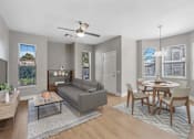 Thumbnail 17 of 63 - A living room with a grey couch, a coffee table, and a dining table with chairs.