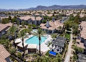 Thumbnail 62 of 63 - A large swimming pool surrounded by palm trees and apartment buildings.