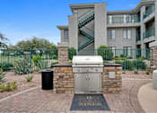 Thumbnail 45 of 58 - an outdoor kitchen with a grill and a trash can in front of an apartment building