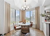Thumbnail 25 of 58 - a dining room with large windows and a chandelier