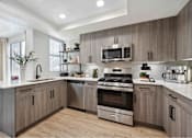 Thumbnail 24 of 58 - a kitchen with gray cabinets and white countertops