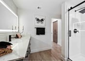 Thumbnail 28 of 58 - a bathroom with white walls and a black and white painting on the wall