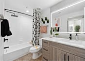 Thumbnail 27 of 58 - a bathroom with a white toilet next to a bathtub with a shower curtain