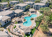 Thumbnail 55 of 58 - an aerial view of a resort style pool with chaise lounge chairs and umbrellas