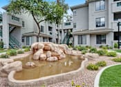 Thumbnail 52 of 58 - a pond sits in the middle of an apartment complex