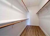 Thumbnail 20 of 58 - a spacious walk in closet with a wood floor and white walls