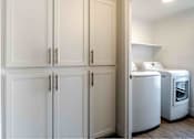 Thumbnail 21 of 58 - a laundry room with white cabinets and washer and dryer