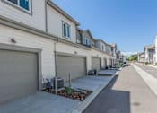 Thumbnail 13 of 23 - A row of houses with garages and driveways at Bloom Rental Living apartments in Fort Collins, CO.