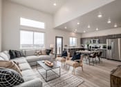 Thumbnail 8 of 12 - A modern living room with a grey sofa and a glass coffee table.