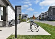 Thumbnail 24 of 79 - A row of bike racks are lined up on a sidewalk in front of a building.
