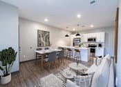 Thumbnail 34 of 79 - A modern kitchen and dining area with a large painting on the wall.