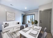 Thumbnail 35 of 79 - A modern dining room with a white table and grey chairs.