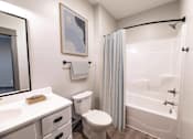 Thumbnail 60 of 79 - A white bathroom with a toilet, sink, and shower.