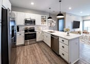 Thumbnail 42 of 79 - A modern kitchen with white cabinets and stainless steel appliances.