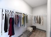 Thumbnail 48 of 79 - A row of clothes hanging on a rack in a room.