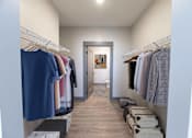 Thumbnail 41 of 79 - A walk in closet with clothes hanging on racks.