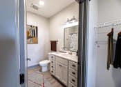 Thumbnail 57 of 79 - A bathroom with a toilet, sink, and mirror.