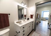 Thumbnail 49 of 79 - A bathroom with a white vanity and a large mirror.