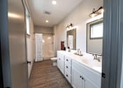 Thumbnail 78 of 79 - A bathroom with a white vanity and a walk-in shower.