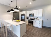 Thumbnail 64 of 79 - A modern kitchen with white cabinets and a central island.