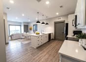 Thumbnail 67 of 79 - A modern kitchen with a dining area and a living room.