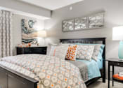 Thumbnail 3 of 24 - A bedroom with a large bed and a painting on the wall.