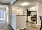 Thumbnail 2 of 24 - A kitchen with a white counter and a refrigerator.