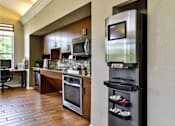 Thumbnail 13 of 24 - Cafe area in clubhouse with a coffee machine, and dishwasher, next to a working station at The Villas at Mainstreet apartments in Ann Arbor, MI.