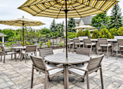 Thumbnail 18 of 24 - A patio with a table and chairs under umbrellas.